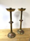 A pair of Arts and Crafts candlesticks with bowl drip tray, saucer knop to centre on circular