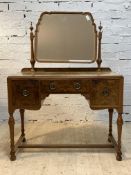 A figured walnut dressing table, the arched bevelled mirror swivelling between turned uprights