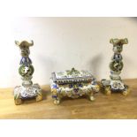 A pair of Rouen Faience candlesticks, (25cm h) and a lidded casket on scrolled supports, a/f, (3)