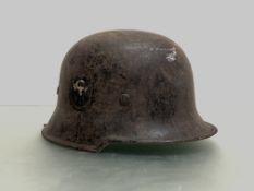 A WWII German Luftscutz helmet in black paint with decals to each side, leather helmet liner