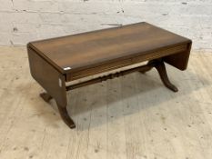 A Georgian style cross banded mahogany low table, fitted with a drop leaf to each end, raised on