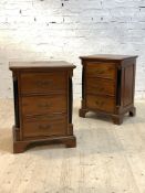 A pair of French Empire style mahogany chests, each with moulded tops over three drawers flanked
