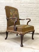 An early 20th century Gainsborough type mahogany framed armchair, the swept open arms enclosing seat