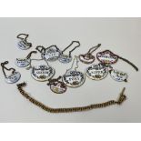 A collection of china and enamel bottle labels and a gilt metal Albert chain (27cm) (a lot)