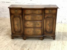Reprodux, A Regency style mahogany break front side cabinet, the cross banded top over four