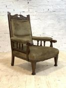 An Edwardian oak framed open armchair, the scrolled acanthus carved and pierced crest rail over