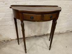 A Georgian style side table with ledgeback serpentine demi lune top over two frieze drawers on