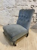 A late 19th early 20thc slipper chair, the scrolled and buttoned back above overstuffed seat, raised