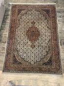 A Persian Tabriz design carpet, the ivory field with pole medallion and mutliple flower heads and