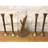 A set of four brass column style candlesticks, (29cm h) and a glass cylindrical vase (5)