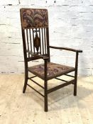 An Edwardian mahogany framed open armchair with floral upholstery, raised on turned supports,