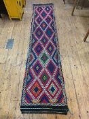 A Susani runner with repeating lozenge motif, (312cm x 67cm)