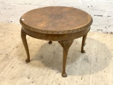 A Queen Anne style figured walnut circular low table, the circular top with running leaf moulded