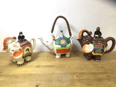A group of three Japanese novelty china teapots all in the form of elephants with riders, (largest
