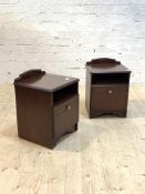 A Pair of mahogany bedside cabinets, each with ledge back over open shelf and cupboard, raised on