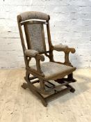 An early 20th century American rocking chair, upholstered, on sledge supports, H106cm ,W56cm, D64cm