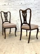 A pair of Edwardian mahogany framed side chairs, with floral carved pierced splat back over