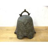 A South East Asian brass bell with naturalistic engraved decoration, lacking clapper, (19cm high)