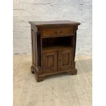 A French Empire style mahogany side cabinet, the moulded top over drawer, open shelf, and