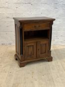 A French Empire style mahogany side cabinet, the moulded top over drawer, open shelf, and