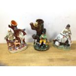 A group of three Staffordshire figures including two spill vases, (17cm h) and a young woman with