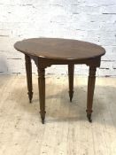 A Scottish 19th century oak library table, the oval top raised on turned reeded supports terminating