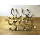 A set of nine Victorian gilt and ceramic wardrobe hooks, (18cm)