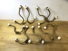 A set of nine Victorian gilt and ceramic wardrobe hooks, (18cm)