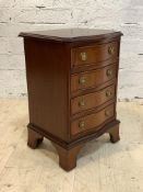 A Georgian style mahogany serpentine chest of small proportions, fitted with four drawers, raised on