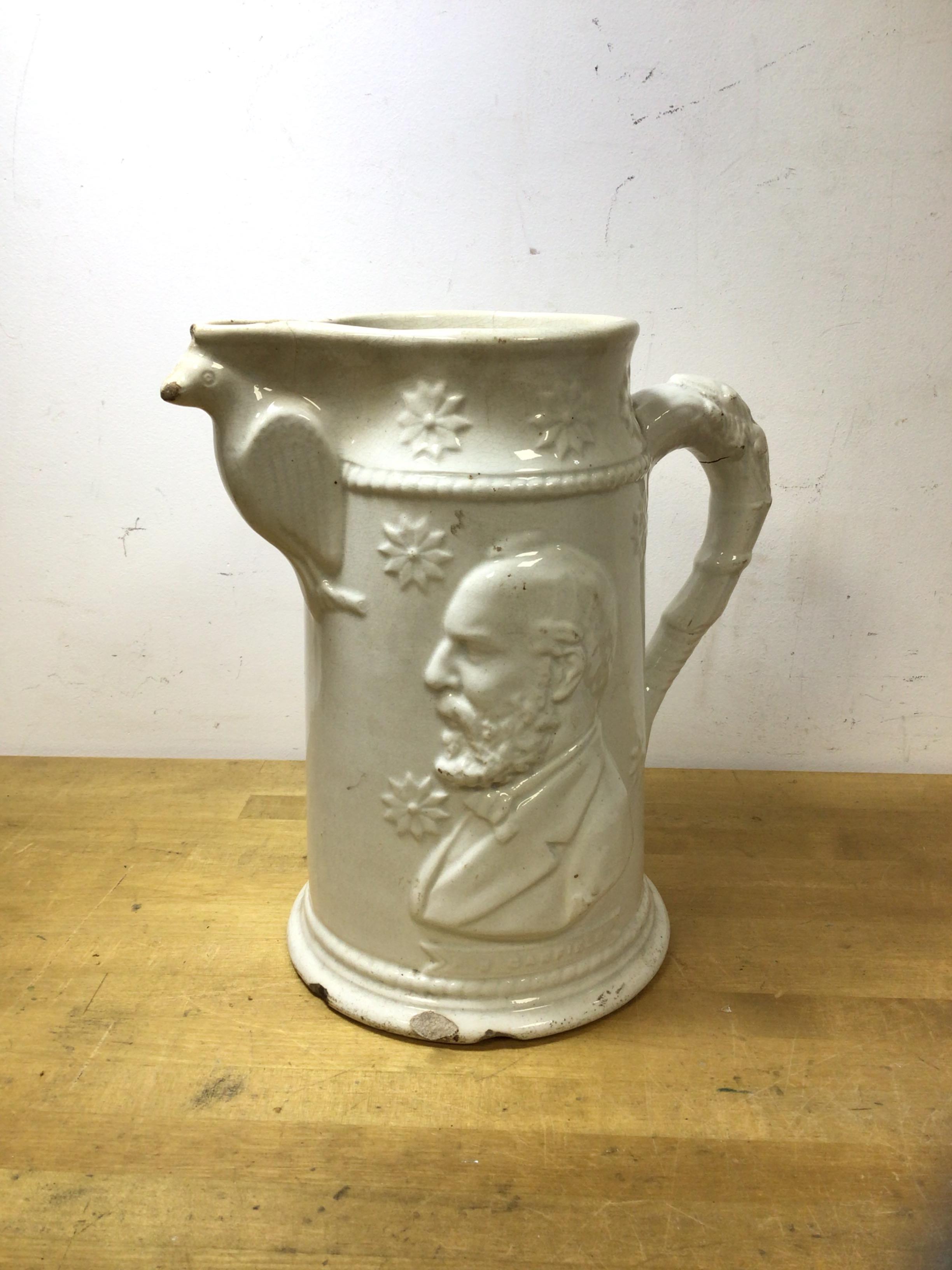 A late 19thc glazed stoneware pitcher depicting President Garfield to either side, spout supported