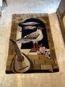 A 20th century tapestry wall hanging depicting bird in window with grapes and lute, initialled AD to