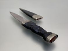 An early 20thc boy's sgian dubh, glass stone in engraved mount, carved ebony handle, steel blade and