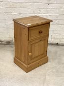 A Pine bedside chest, fitted with one drawer above a cupboard, raised on a plinth base, H60cm,