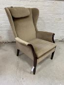 A Parker Knoll armchair with wing back scrolled arms drop in seat cushion on straight supports,