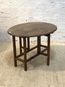 A Cotswold school solid walnut gate leg table, the oval top with unusual reticulated carved edge,