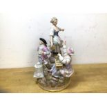 A 19thc Meissen porcelain figural group with two women and gentleman on rocky outcrop, crossed