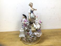 A 19thc Meissen porcelain figural group with two women and gentleman on rocky outcrop, crossed