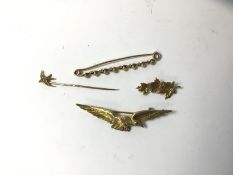 A brooch marked 9ct in the form of a bird, a brooch marked 10k in the form of three maple leaves,