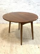 A mid century teak drop leaf dining table, the circular top when open raised on square splayed