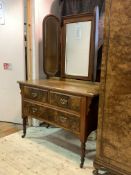 An Edwardian walnut dressing table, the three swing mirrors over moulded top and two short and two