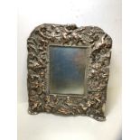A late 19th early 20thc silver plated photo frame with cherubs and scrolling vine in high relief,
