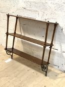 A late Victorian mahogany three tier wall hanging shelf, each tier on turned supports above cast