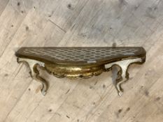 A gilt wood and cream painted Rococo style wall bracket, the top of undulating form over and