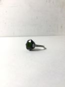 A white metal green beryl set ring with three diamonds to each shoulder, beryl approximately 2ct,