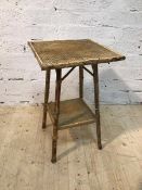 A cane and wicker occasional table the square top on supports united by undertier, (67cm x 42cm x