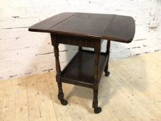 A 1920's / 30's oak hostess trolley with drop leaves to sides, single frieze drawer on turned