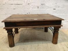 An Indonesian hardwood coffee table, metal bound, the moulded rectangular top on turned supports