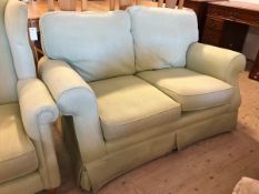 A two seater sofa with scrolled arms in later mint green upholstery, (80cm x 138cm x 97cm)