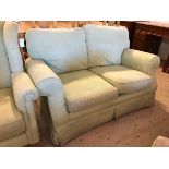 A two seater sofa with scrolled arms in later mint green upholstery, (80cm x 138cm x 97cm)