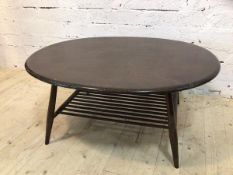 An Ercol coffee table the ovoid top over spindle lower tier on turned splayed supports (44cm x 100cm